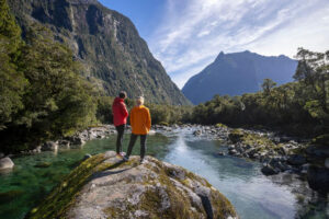 Fiordland Premium Explorer Package Couple Stands On Rock Over Looking River
